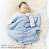 TinyBitz personalized knitted blanket in light blue background, customized with baby's name and made from 100% cotton.