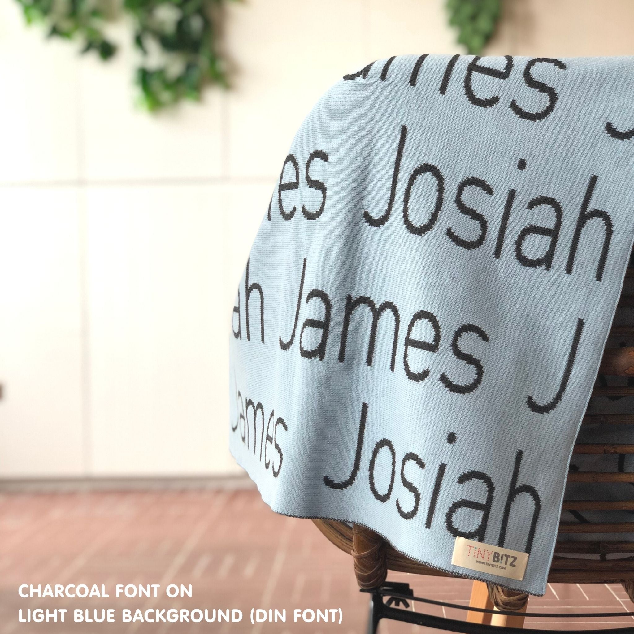 Knitted baby blanket in light blue and charcoal, customised with baby's name, made by TinyBitz.