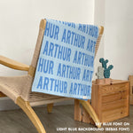 Customisable blanket with adult's name knitted in light blue and sky blue, personalized by TinyBitz.