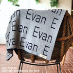 Custom name blanket in light grey and navy draped over a chair makes the best personalized home decor.