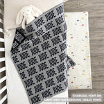Cotton baby blanket with baby's name knitted in light grey and charcoal, made by TinyBitz.