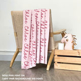 Custom name blanket in light pink and rose pink draped over a chair makes the best personalized home decor.