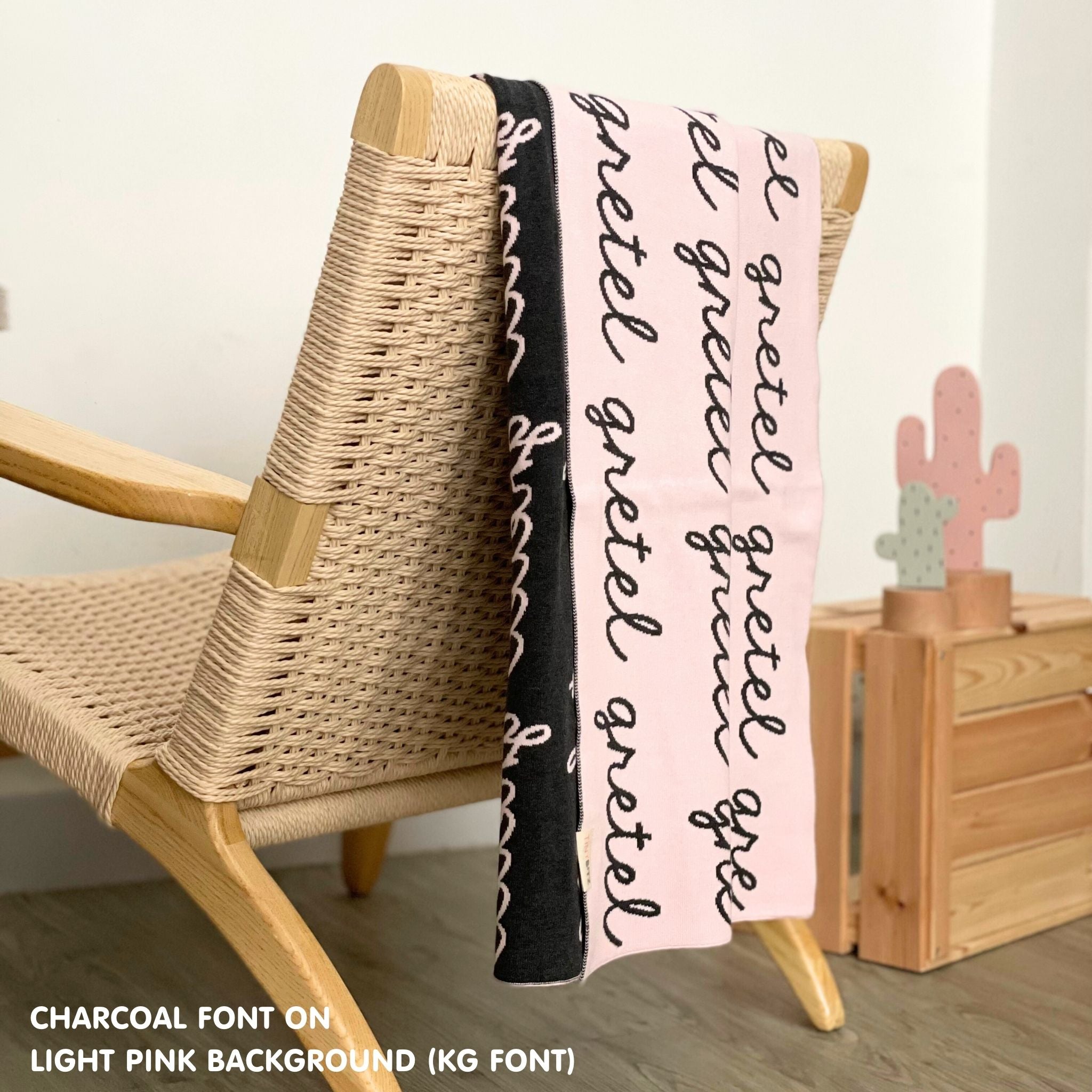 Custom name blanket in light pink and charcoal draped over a chair makes the best personalized home decor.