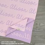 Customisable blanket with adult's name knitted in light pink and light purple, personalized by TinyBitz.