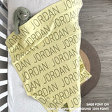 TinyBitz personalized knitted blanket in light yellow background, customized with baby's name and made from 100% cotton.