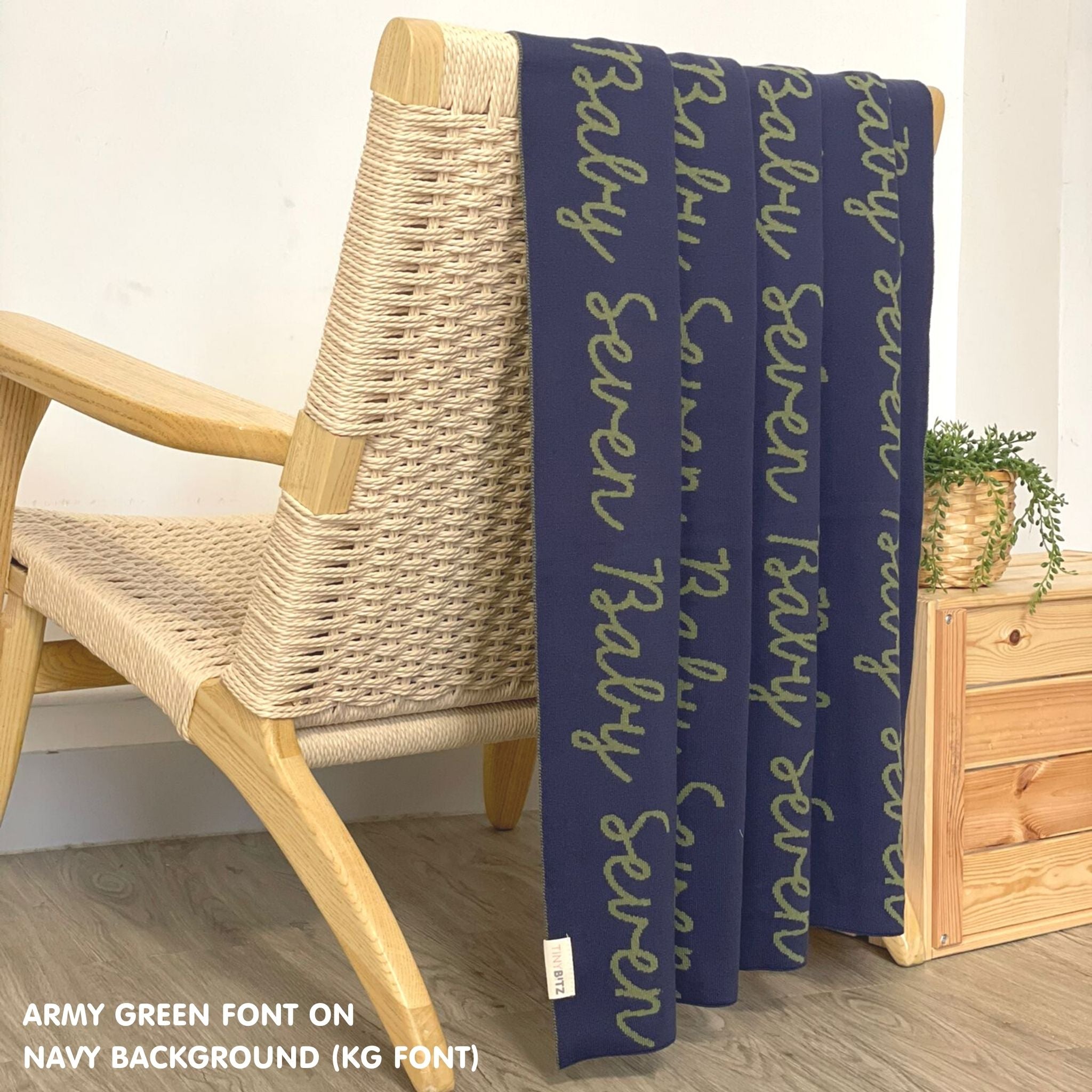 Customisable blanket with adult's name knitted in navy and army green, personalized by TinyBitz.