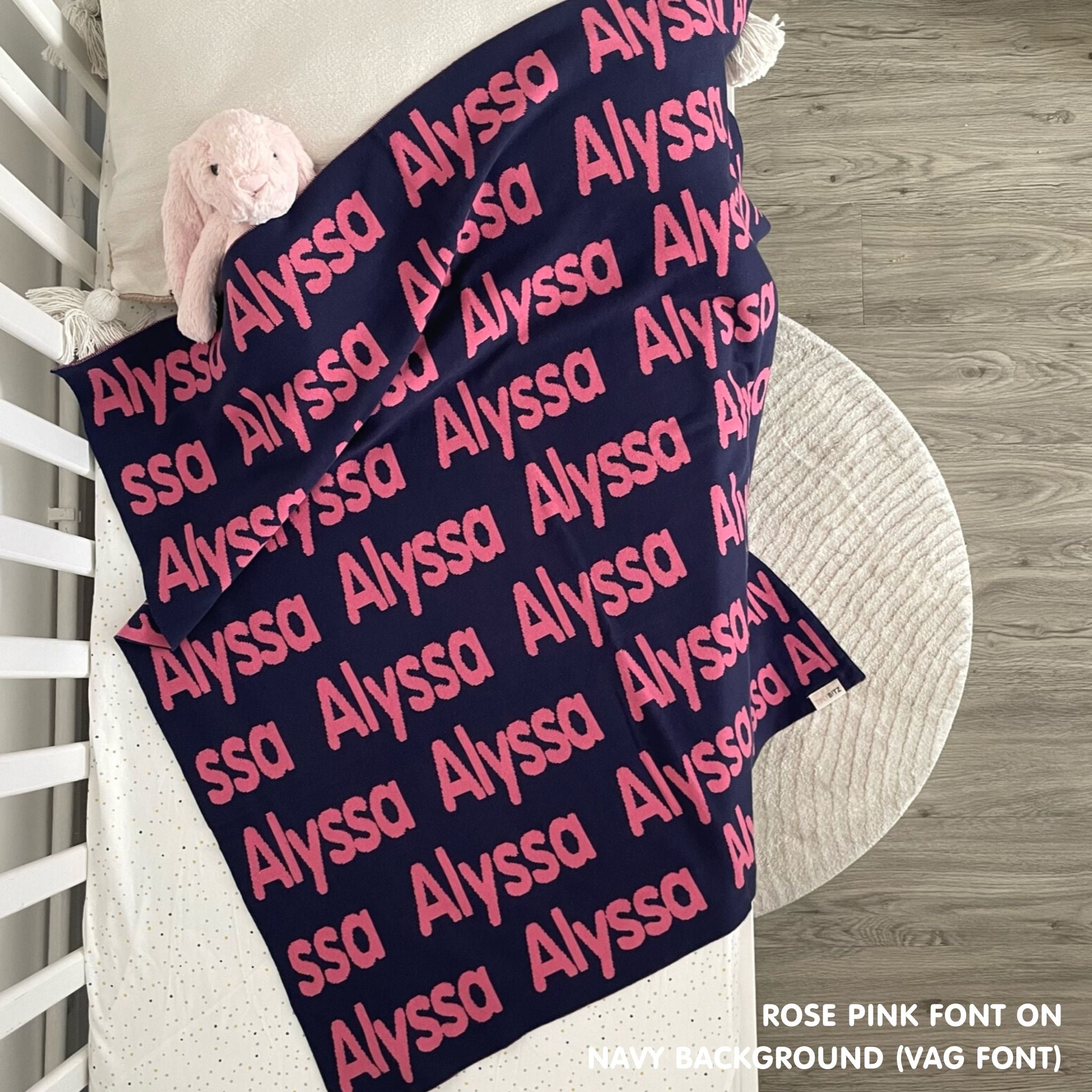Baby blanket knitted from cotton personalized with baby's name in navy and rose pink, made by TinyBitz.