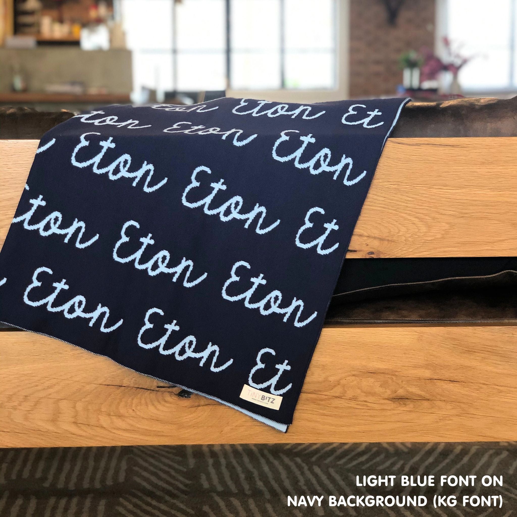 Custom name blanket in navy and light blue draped over a chair makes the best personalized home decor.