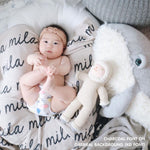 TinyBitz personalized knitted blanket in oatmeal background, customized with baby's name and made from 100% cotton.