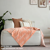 Custom name blanket draped on sofa, knitted in peach and white makes the best personalised home decor.