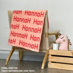 Customisable blanket with adult's name knitted in peach and coral, personalized by TinyBitz.