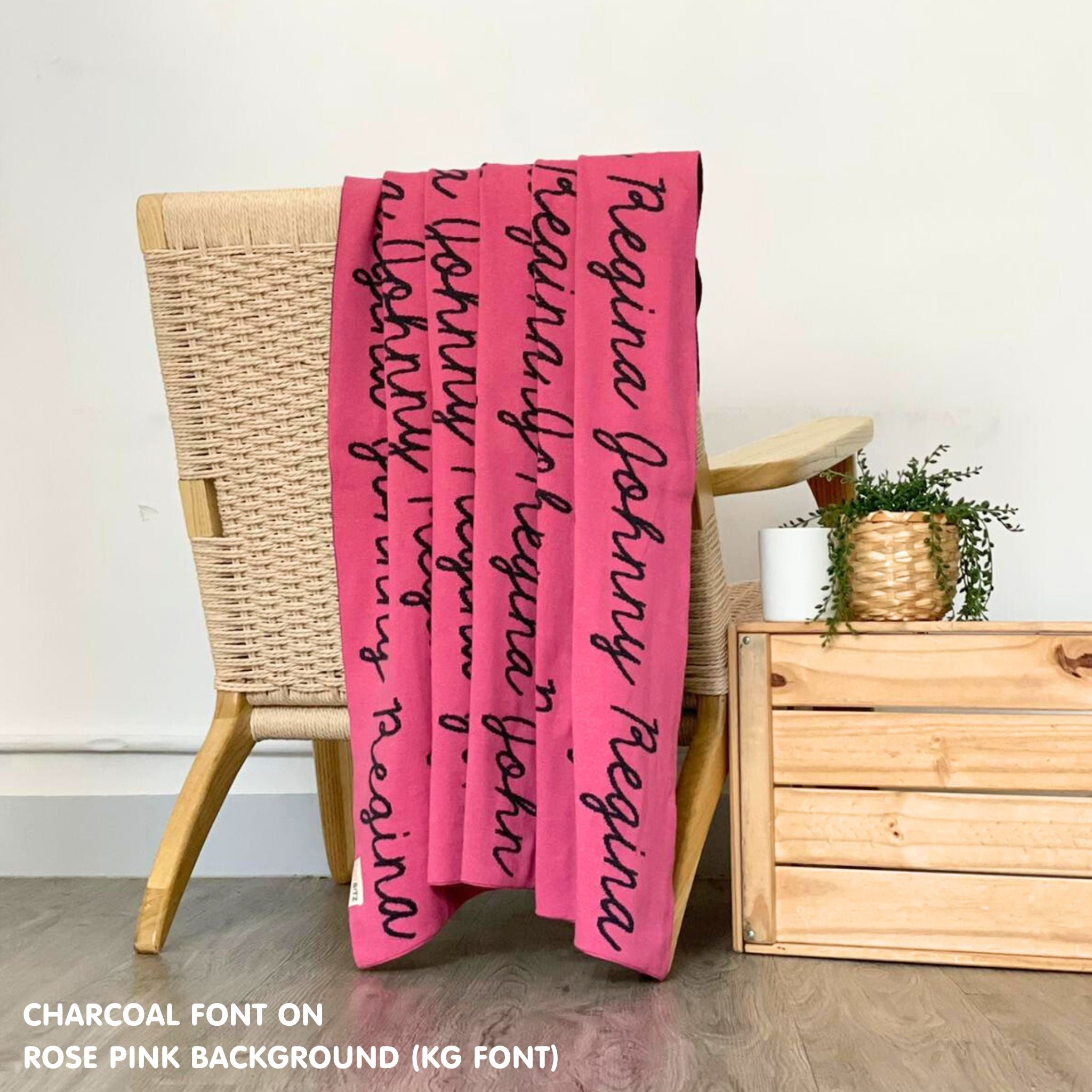 Customisable blanket with adult's name knitted in rose pink and charcoal, personalized by TinyBitz.