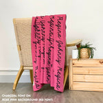 Personalised pet blanket in rose pink and charcoal knitted cotton, custom dog blanket by TinyBitz, styled on modern wooden dog bed.