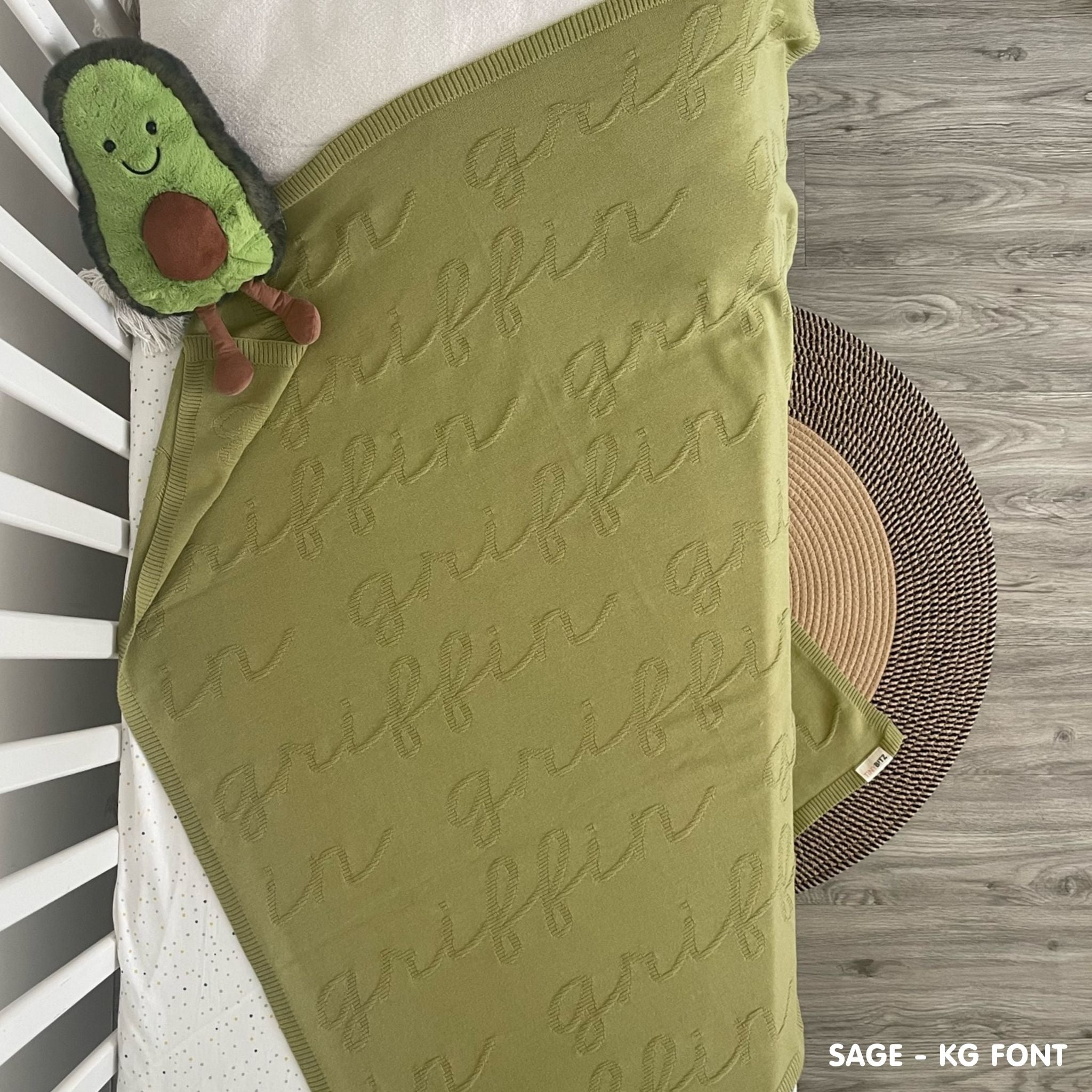 TinyBitz knitted baby boy blanket in sage background, one colour with monogram, personalized with your baby’s name.