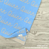 Customisable blanket with adult's name knitted in sky blue and stone, personalized by TinyBitz.