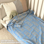 Cotton baby blanket with baby's name knitted in sky blue and light grey, made by TinyBitz.