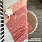Knitted baby blanket in dusty pink and peach with a twinkles pattern, customised with baby's name, made by TinyBitz.