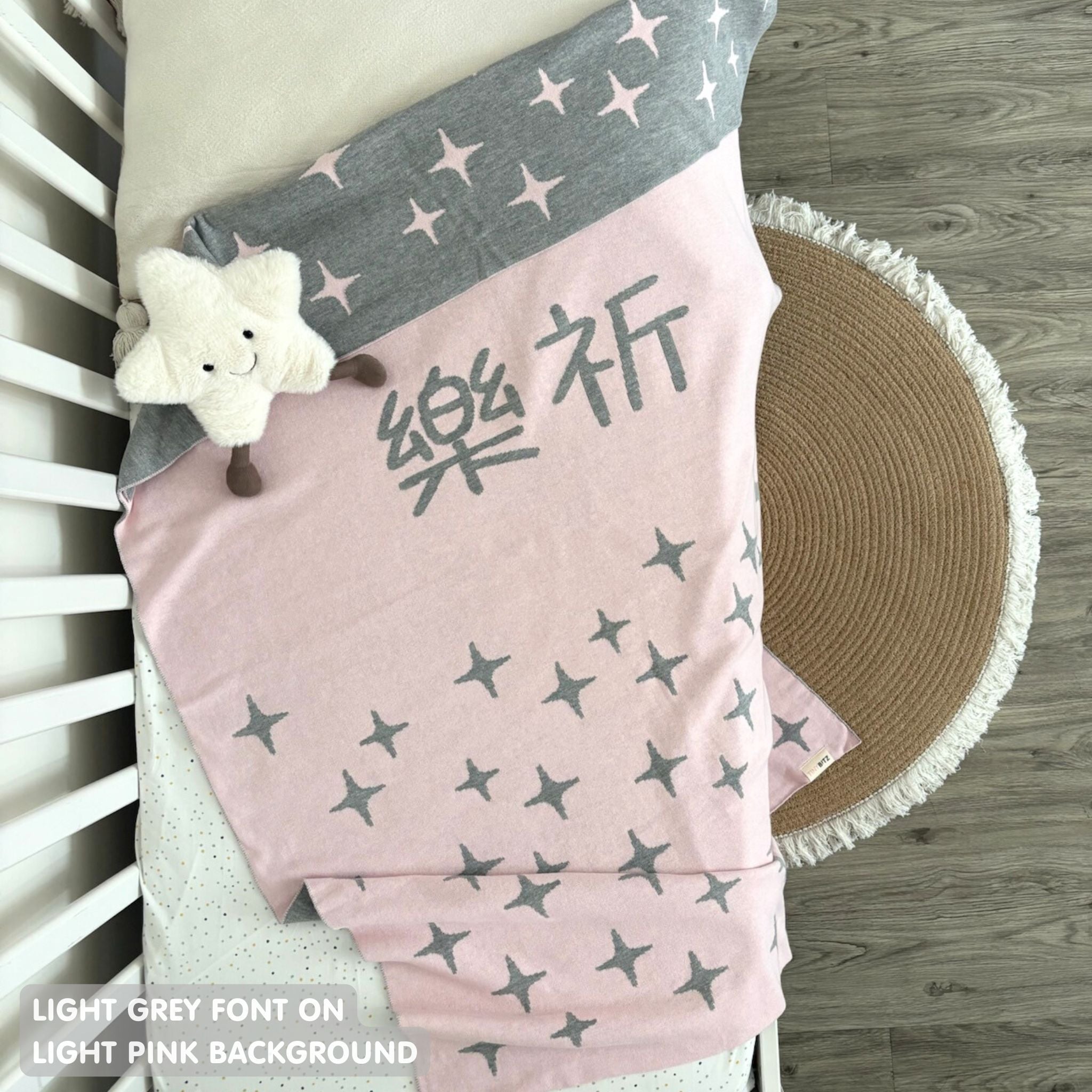 TinyBitz custom knitted blanket with baby's name on light pink background with a twinkles pattern, best gift to welcome a newborn baby.