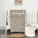 Cotton baby blanket with baby's name knitted in stone and white with a twinkles pattern, made by TinyBitz.