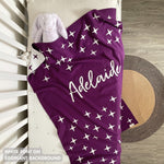 TinyBitz custom knitted blanket with baby's name on eggplant background with a twinkles pattern, best gift to welcome a newborn baby.