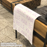 Custom name blanket in white and light pink draped over a chair makes the best personalized home decor.