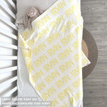 TinyBitz knitted baby boy blanket in white background and light yellow, personalized with your baby’s name.