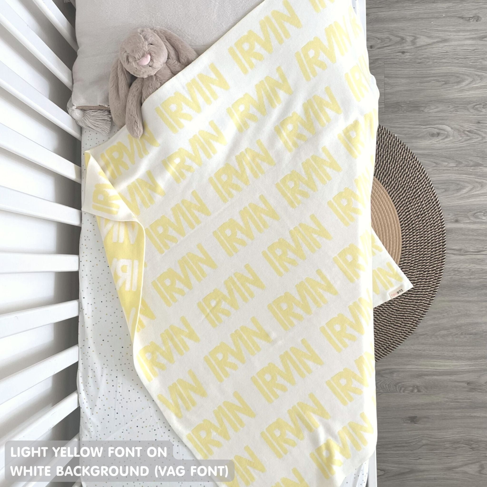 TinyBitz knitted baby boy blanket in white background and light yellow, personalized with your baby’s name.