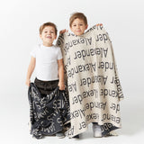 TinyBitz Kids Blanket in charcoal and oatmeal, personalized with child's name and made from 100% cotton.