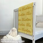 TinyBitz knitted cotton blanket in light yellow and mustard, personalized with your kid’s name.