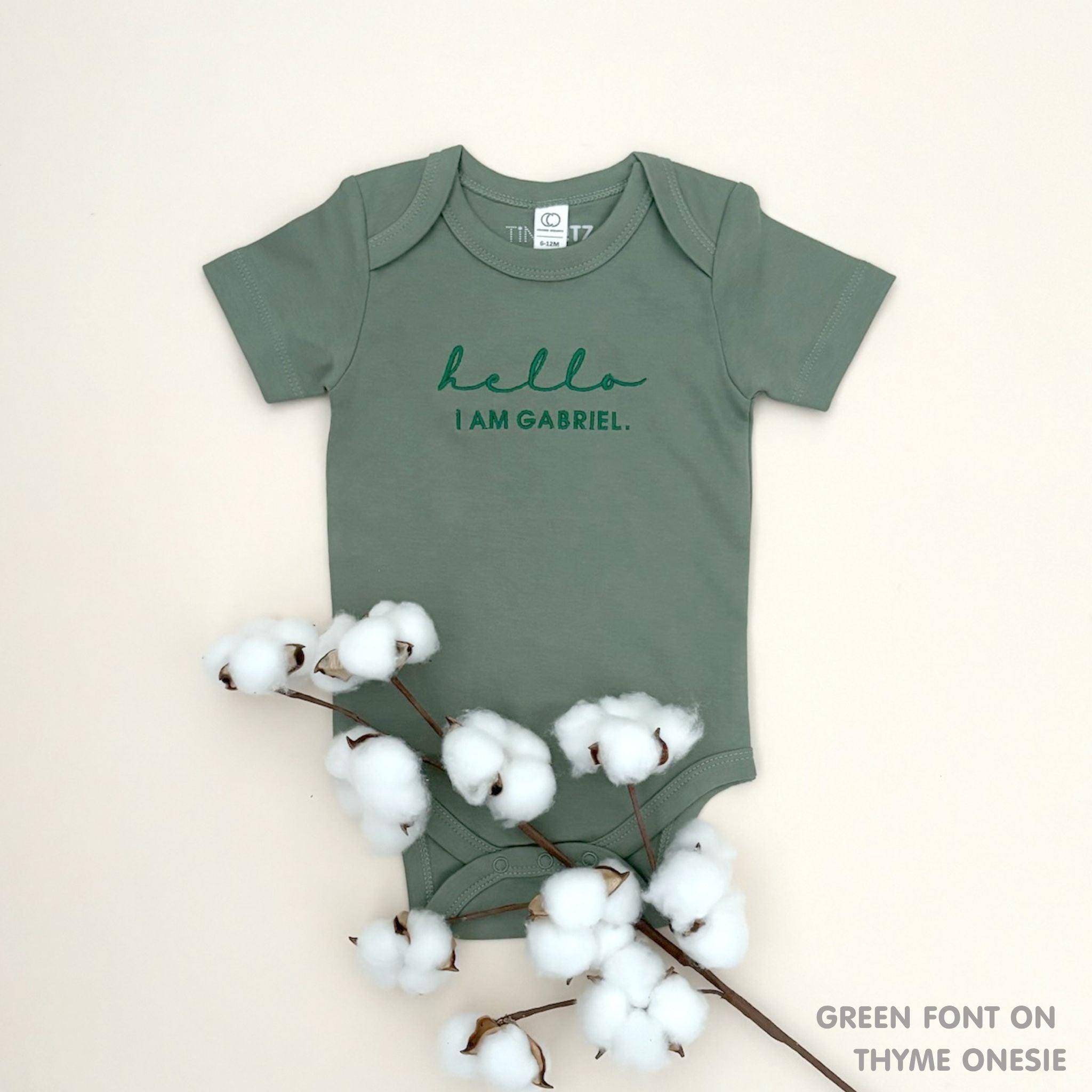 TinyBitz Custom baby onesie in thyme with name embroidery, unique outfit for baby’s birth announcement or first photoshoot.