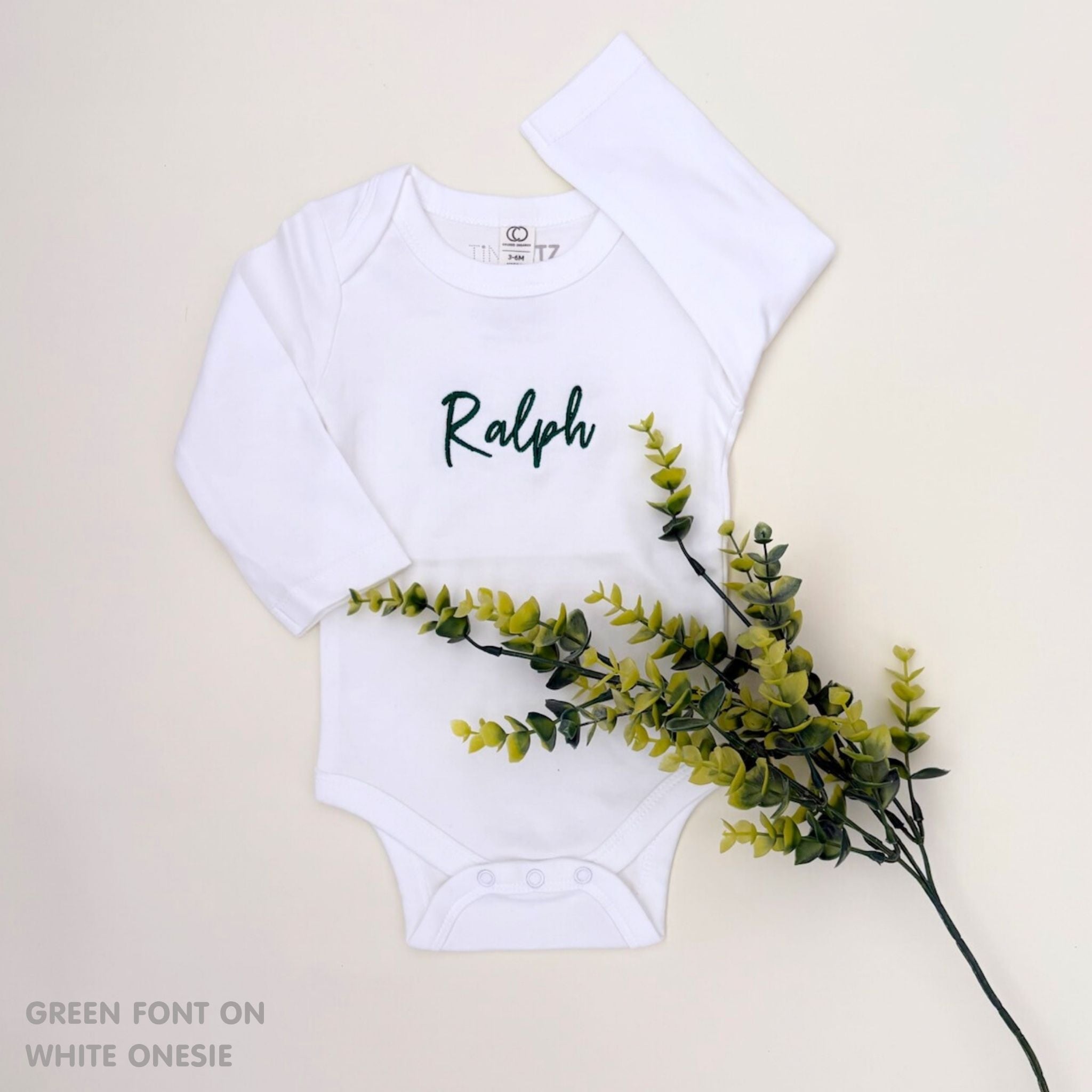 Organic cotton baby onesie with custom name, ideal for birth announcements, baby shower gifts, and keepsakes by TinyBitz.