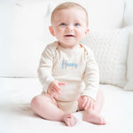 TinyBitz Custom baby onesie in cream with name embroidery, unique outfit for baby’s birth announcement or first photoshoot.