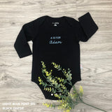 Organic cotton black onesie for babies with embroidered name, personalized baby shower gift keepsake from TinyBitz.