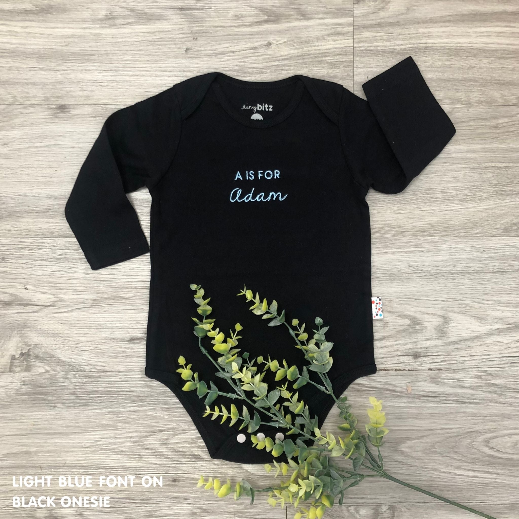 Organic cotton black onesie for babies with embroidered name, personalized baby shower gift keepsake from TinyBitz.
