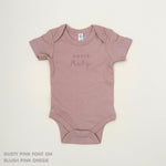 TinyBitz Personalised baby onesie with embroidered name in soft blush pink cotton, perfect for birth announcements and newborn photos.