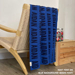 Personalised pet blanket in blue and navy knitted cotton, custom dog blanket by TinyBitz, styled on modern wooden dog bed.