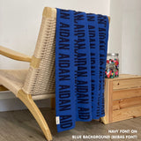 Personalised pet blanket in blue and navy knitted cotton, custom dog blanket by TinyBitz, styled on modern wooden dog bed.