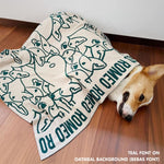 Personalised pet blanket for Corgi in oatmeal and teal knitted cotton, custom dog blanket by TinyBitz, styled on modern wooden dog bed.