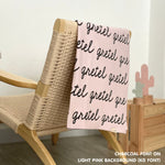 Personalised pet blanket in light pink and charcoal knitted cotton, custom dog blanket by TinyBitz, styled on modern wooden dog bed.