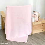 Baby blanket knitted from cotton personalized with baby's name in light pink background, made by TinyBitz.