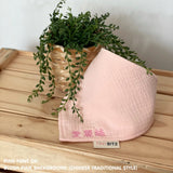 Personalized blush pink organic muslin bib with custom name embroidery, perfect for baby gifts and keepsake accessories.