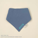 Personalized dusty blue organic muslin bib with custom name embroidery, perfect for baby gifts and keepsake accessories.