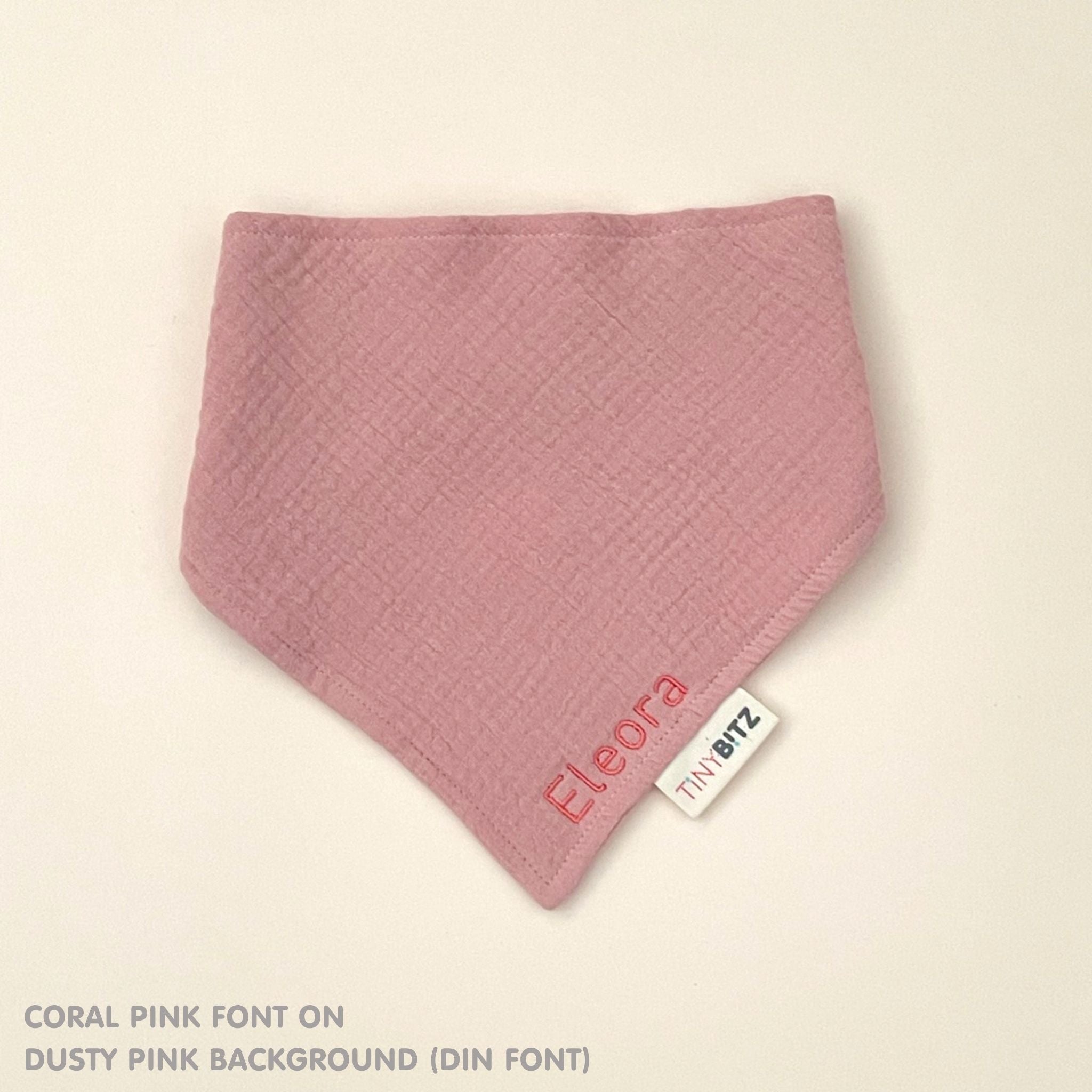 Custom baby bib in dusty pink with embroidered name, personalised baby gift made from breathable muslin by TinyBitz.
