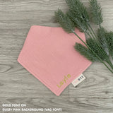 Personalized dusty pink organic muslin bib with custom name embroidery, perfect for baby gifts and keepsake accessories.