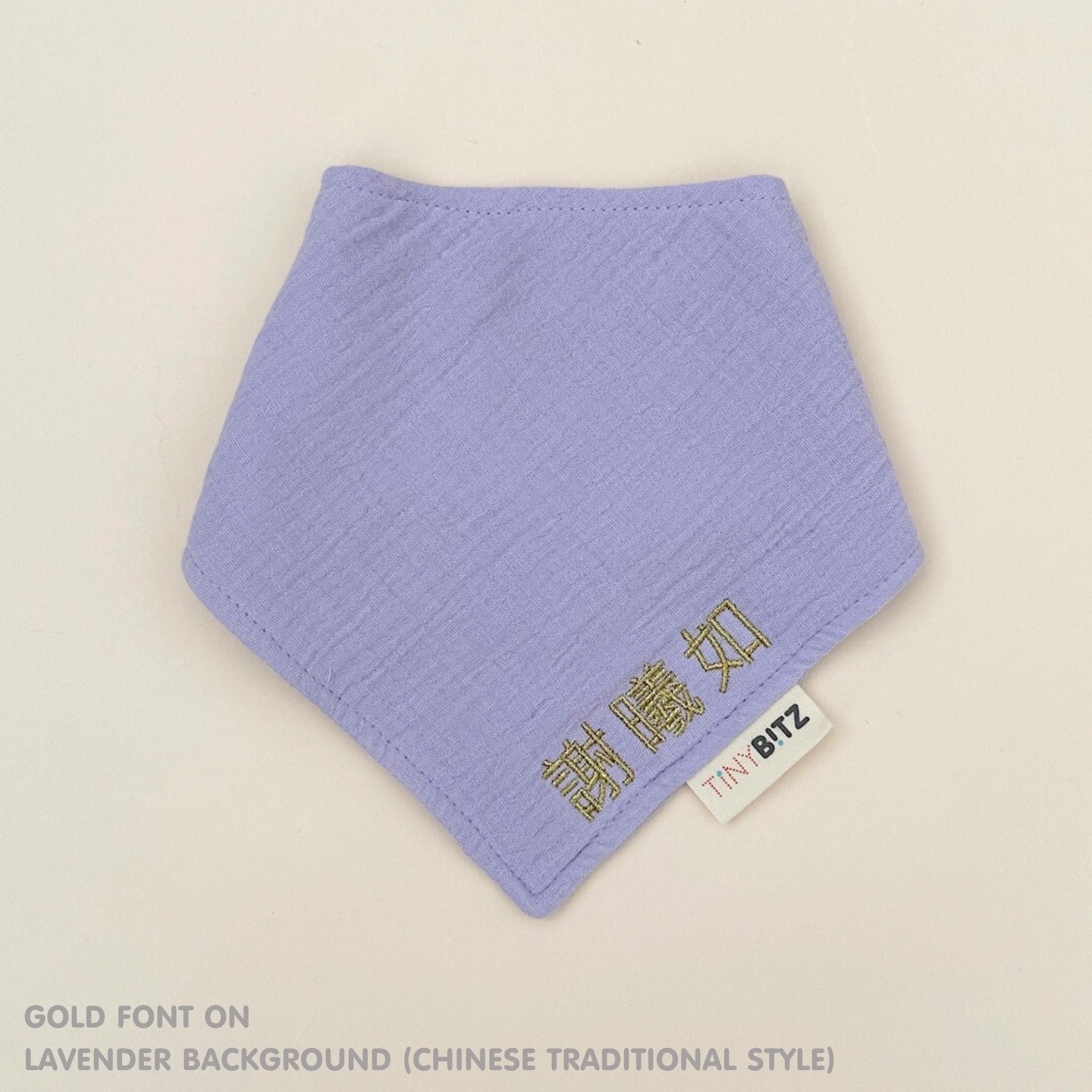Personalized lavender organic muslin bib with custom name embroidery, perfect for baby gifts and keepsake accessories.