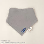 Personalized light grey organic muslin bib with custom name embroidery, perfect for baby gifts and keepsake accessories.