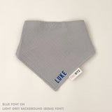 Personalized light grey organic muslin bib with custom name embroidery, perfect for baby gifts and keepsake accessories.