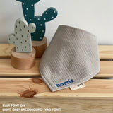 Personalized light grey organic muslin bib with custom name embroidery, perfect for baby gifts and keepsake accessories.