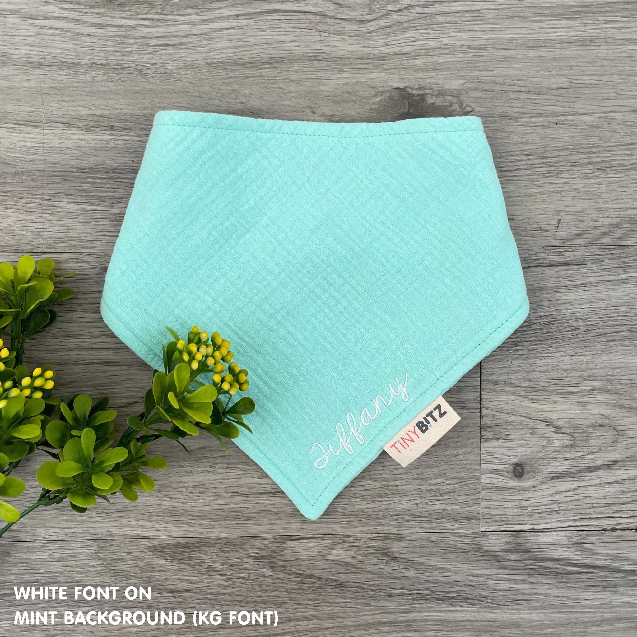 Custom baby bib in mint with embroidered name, personalised baby gift made from breathable muslin by TinyBitz.