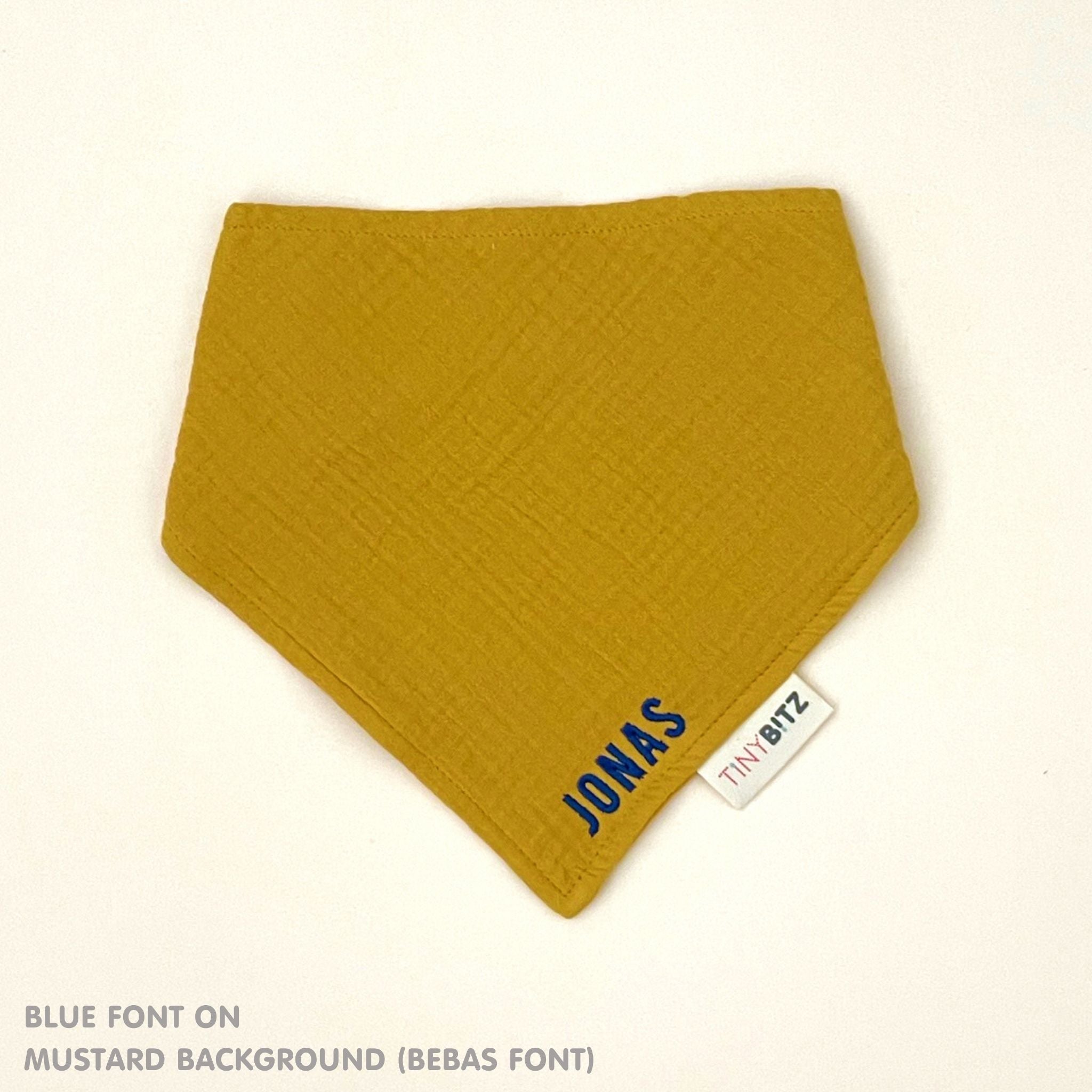 Organic personalised bib for babies in mustard, featuring baby name in script font, unique baby gift idea by TinyBitz.